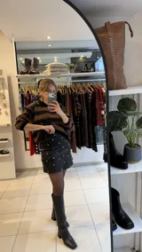 Falda corta de gabardina elastizada color negro, con diseño de tachas metálicas plateadas distribuidas por toda la prenda.