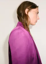 Americana de corte recto y estilo sastre, color violeta, con cuello de solapa, cierre frontal de un botón y dos bolsillos con solapa. Presenta diseño de manga larga y forro interior.