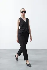 Pantalón negro de corte recto, con cintura definida y bolsillos funcionales.