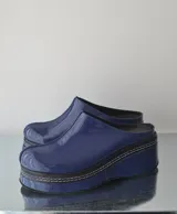 Suecos de charol azul con plataforma y costuras blancas.