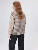 Remera de manga larga con diseño a rayas horizontales en tonos celestes y blancos en el cuerpo, y mangas a rayas azul marino y blancas. Presenta cuello redondo en color azul marino, logo bordado en el pecho y calce holgado.