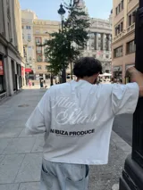Remera celeste de corte holgado con estampado en la espalda que dice "Ittai Stars" en letras cursivas y "An Ibiza Produce" en mayúsculas.
