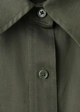 Mono largo verde militar de mezcla de lino y lyocell, con diseño recto, cuello camisero, manga corta y bolsillos laterales. Incluye cierre frontal con botones y cinturón ancho con hebilla metálica.
