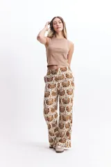 Pantalón wide leg estampado con diseño de conchas marinas en tonos verde oscuro y blanco. Presenta un calce relajado y cintura media.