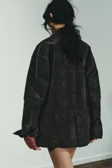 Cazadora oversize de piel de ante 100%, con cuello solapa, manga larga, bolsillos laterales de vivo y bolsillo de plastrón en el pecho. Cuenta con forro interior a tono y cierre frontal con botones.