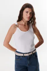 Musculosa negra ajustada al cuerpo con escote redondo y tirantes finos. Presenta un detalle metálico en forma de aro o hebilla en la unión del tirante con el cuerpo de la prenda.