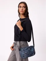 Bolso tipo morral de la marca Rusty, con diseño estampado camuflado en tonos marrones. Cuenta con correa ajustable y cierre frontal con logo de la marca.