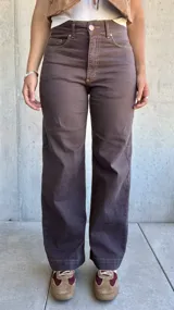 Jean de corte recto y tiro alto en color marrón chocolate, con costuras a contratono y cierre frontal con botón metálico.