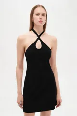 Vestido corto de viscosa color negro, ajustado al cuerpo, con cuello halter cruzado y detalle de abertura superior.