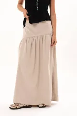 Pollera larga de color negro, con corte a la cadera y falda con frunce que aporta volumen y movimiento. Confeccionada en tela suave con acabado tipo piel de durazno.