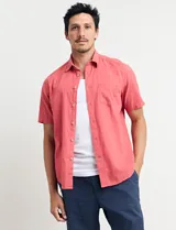 Camisa sport de manga corta, confeccionada en una mezcla de lino y algodón. Presenta cuello clásico, cierre frontal con botones de coco y un bolsillo aplicado en el pecho.