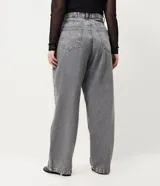 Pantalón de jean de corte recto y tiro medio, color gris con acabado lavado y aplicaciones de brillos distribuidas en las piernas. Cuenta con diseño de cinco bolsillos, cierre frontal con botón y costuras reforzadas.