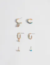 Set de seis aros dorados con detalles celestes. Incluye un aro tipo cuff, dos aros tipo argolla, un aro con forma de eslabón y dos aros tipo botón, uno con forma de corazón celeste y otro con tres strass.