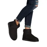 Botas cortas UGG Classic Mini II de gamuza color negro, con interior de piel de oveja y suela de goma.