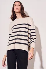 Sweater beige con rayas horizontales negras, de corte holgado y mangas largas.