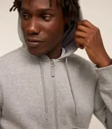 Buzo deportivo negro con capucha, cierre frontal con cremallera, bolsillos laterales y puños ajustados. Confeccionado en tejido de algodón y poliéster.