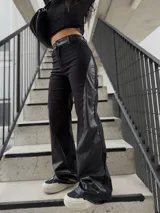 Pantalón de tiro alto con diseño combinado en bengalina y paneles laterales de eco cuero. Presenta un corte recto y holgado con cierre frontal y bolsillos laterales.