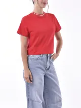 Remera de algodón color rojo, con cuello redondo, mangas cortas y detalle de frunce central en la parte inferior.