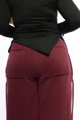 Pantalón de silueta recta amplia confeccionado en felpa de algodón. Presenta cintura elastizada, bolsillos laterales con largas tiras decorativas y bolsillos traseros plaqué.