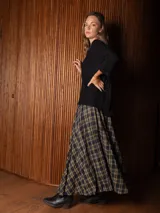 Pollera larga de corte amplio y voluminoso, con estampado de cuadros escoceses en tonos azul marino y amarillo. Presenta cintura elástica y bolsillos laterales.