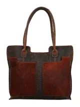 Bolso tote de cuero marrón oscuro con paneles frontales de pelo (pelo vacuno) en tono marrón rojizo. Presenta costuras decorativas en los bordes y un trenzado central de cuero oscuro. Tiene asas de hombro de cuero desgastado.