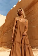 Vestido largo tostado de corte holgado, con tirantes anchos estampados, escote redondo y falda con volado fruncido en el ruedo.