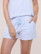 Pijama de short y remera en tejido acanalado fino con estampado floral en tonos celestes sobre fondo blanco. Remera de escote redondo con botones frontales y mangas cortas. Short con cintura elastizada, cordón de ajuste y bolsillos frontales.