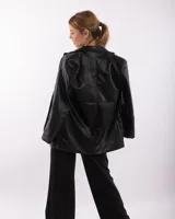 Blazer negro de cuerina con solapas de muesca, cierre con un botón, bolsillos delanteros con solapa y corte holgado.