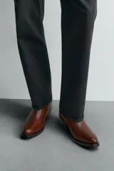 Bota de cuero color marrón, estilo cowboy, con caña corta, puntera en punta y tacón cubano.