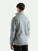 Campera de punto color gris con cierre frontal metálico y cuello alto, forrada en polar.