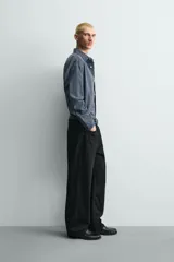 Pantalón jeans de corte recto y ajuste holgado, confeccionado en denim de algodón rígido. Presenta diseño clásico de cinco bolsillos, cierre frontal con cremallera y botón, con un acabado de lavado claro.