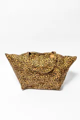 Bolso tipo tote con diseño amplio y estampado animal print de leopardo en tonos marrones y negros. Cuenta con doble asa superior y un bolsillo frontal con solapa.