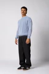 Sweater de punto grueso con textura waffle, de calce relajado y cuello redondo. Presenta puños y ruedo acanalados, con un pequeño parche con logo en el puño izquierdo.