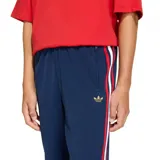 Pantalón deportivo Adidas Firebird de color azul marino, corte recto, con cintura elástica y bolsillos laterales con cierre. Presenta una franja lateral tricolor (rojo, blanco, rojo) y el logo del trébol bordado en dorado en el muslo.