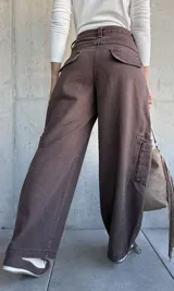 Jean de corte barrel color chocolate, con diseño cargo que incluye bolsillos laterales amplios. Presenta tiro medio y costuras reforzadas en las piernas.