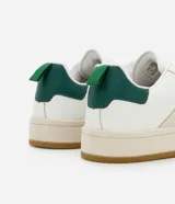Championes de estilo casual, color blanco, con detalles en beige claro en los laterales y puntera de gamuza color gris claro. Posee suela de goma color caramelo y tirador trasero en color verde oscuro.