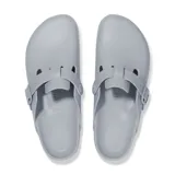 Zueco Birkenstock modelo Boston fabricado en material EVA ligero y flexible, color gris piedra. Presenta diseño cerrado con puntera redondeada, plantilla anatómica y tira ajustable con hebilla lateral grabada con el logo de la marca.