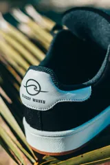 Championes negros de gamuza con detalles en blanco, suela blanca con base color caramelo y cordones negros.