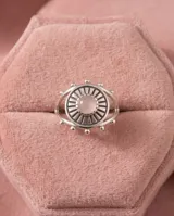 Anillo de plata 925 con diseño circular tipo sol y piedra central de cuarzo rosa.