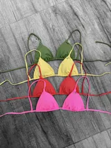 Corpiño de bikini tipo triángulo con copas removibles. Se ata en la espalda y tiene tiras ajustables que también permiten atarlo al cuello.