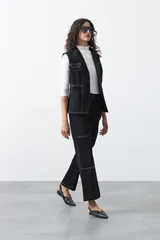 Pantalón de corte recto y tiro medio, confeccionado en algodón con elastano. Presenta costuras a contratono en color blanco que resaltan los recortes delanteros y el diseño de la prenda, aportando un estilo utilitario.