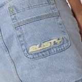 Pollera corta de jean, color celeste lavado, con tiro medio/bajo y corte recto. Presenta costuras visibles y bolsillos delanteros y traseros típicos de jean.