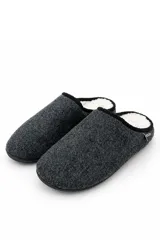 Pantuflas Boccato de tipo destapado en el talón, confeccionadas en tejido exterior texturizado gris oscuro con ribete negro e interior de corderito sintético blanco.