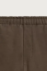 Pantalón jogger de corte regular fit y color negro, confeccionado en tejido compacto de algodón con interior de rizo. Cuenta con cintura elástica, bolsillos frontales y un bolsillo trasero de doble vivo.