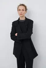 Trench simil gamuza color marrón, con cuello de solapa muesca, cuatro botones delanteros, bolsillos laterales y cinturón a la altura de la cintura.