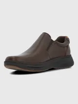 Zapato tipo slip-on de cuero marrón con paneles elásticos laterales para un ajuste cómodo y suela de goma oscura con diseño estriado.