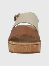 Sandalias de cuero color marrón con plataforma de corcho, tira ancha de cuero sobre los dedos y tira trasera de tela color beige con hebilla.