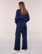Pantalón jogger azul marino de corte recto y ancho, confeccionado en modal. Presenta pretina elastizada, bolsillos tipo cargo en los laterales y costuras verticales decorativas.