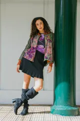 Chaqueta bomber con estampado abstracto en tonos verdes, rosas y naranjas. Tiene cuello, puños y ruedo acanalados en color naranja.