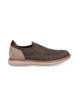 Zapato tipo slip on Hush Puppies modelo Apolo, confeccionado en tejido de poliéster color gris con refuerzo de gamuza en el talón y detalle de tirador rojo. Cuenta con suela de EVA Comfort Flex.